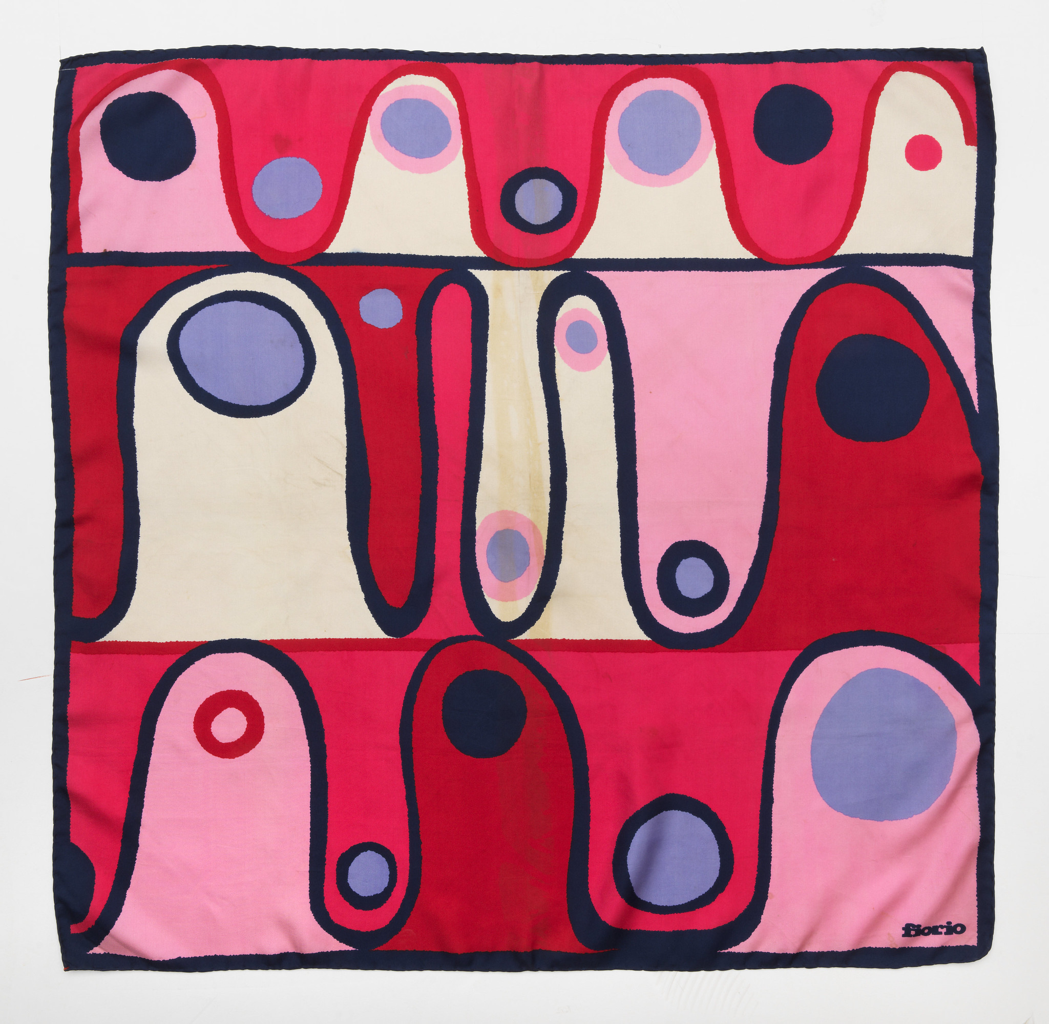A square silk scarf divided into three horizontal sections. Each section contains heavy undulating lines and circles.
