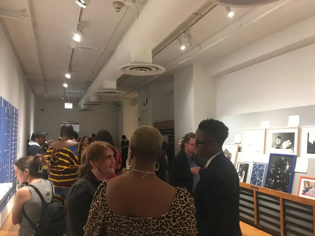 Over 20 people at a reception at the Museum of Contemporary Photography.
