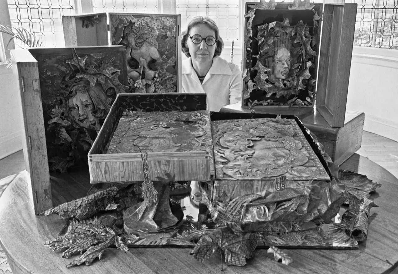 Portrait of Alice Shaddle seated among a collection of her artworks.