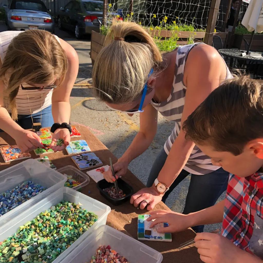 Two women making arts and crafts with a young boy