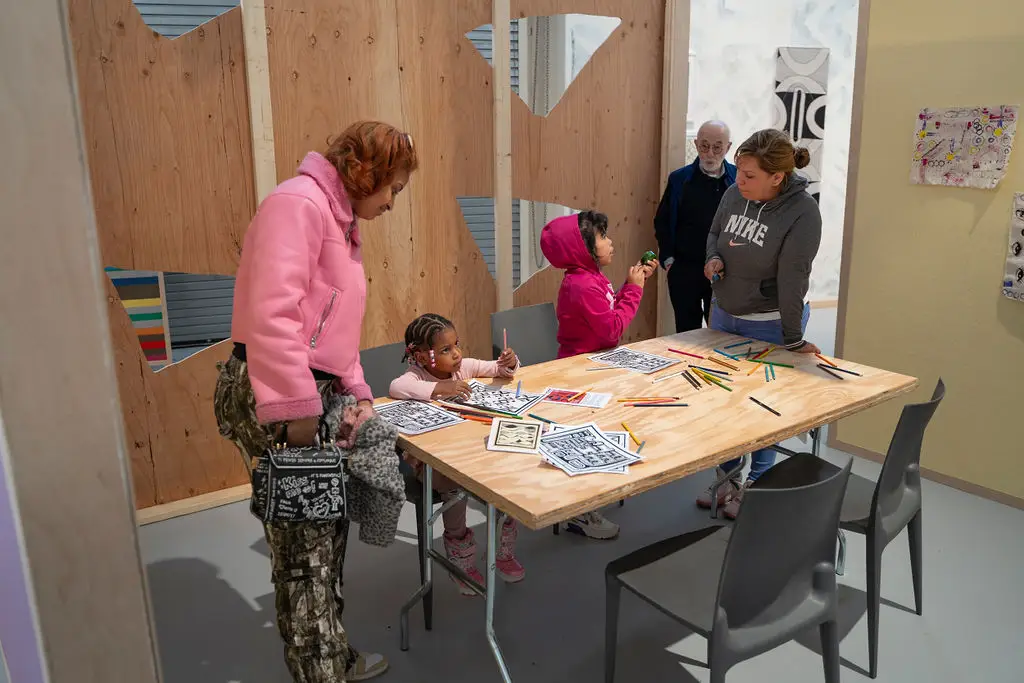 Children and adults around a table working on a craft project.