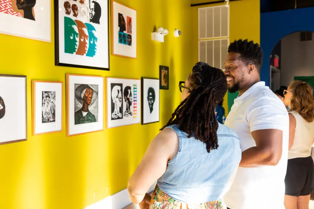 A man and woman looking at a gallery wall.