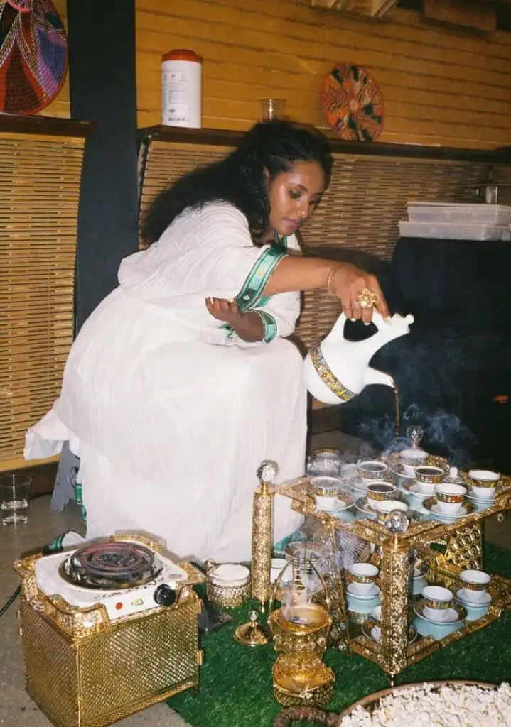 A traditional Jabena Buna Ethiopian Coffee Ceremony, with coffee being poured into a setting of cups on a tray.