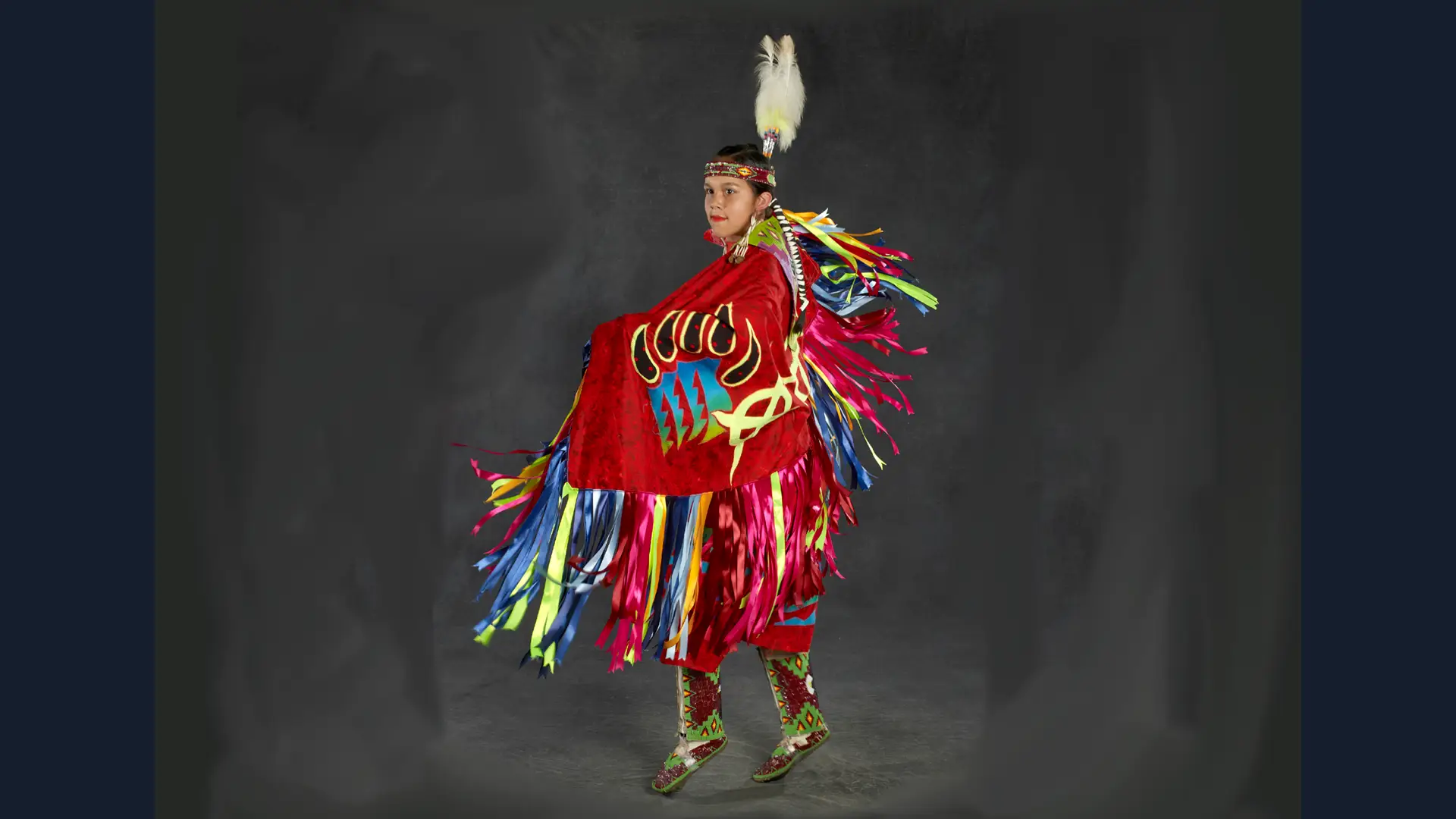 A dancing figure in traditional Native American regalia.